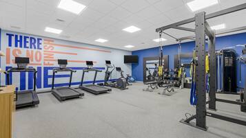 A gym with treadmills, stationary bikes, and weightlifting equipment.