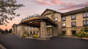 A hotel with a covered entrance, stone facade, and a sign reading 'Hampton Inn & Suites.' - Hampton Inn & Suites Bend (Bend)