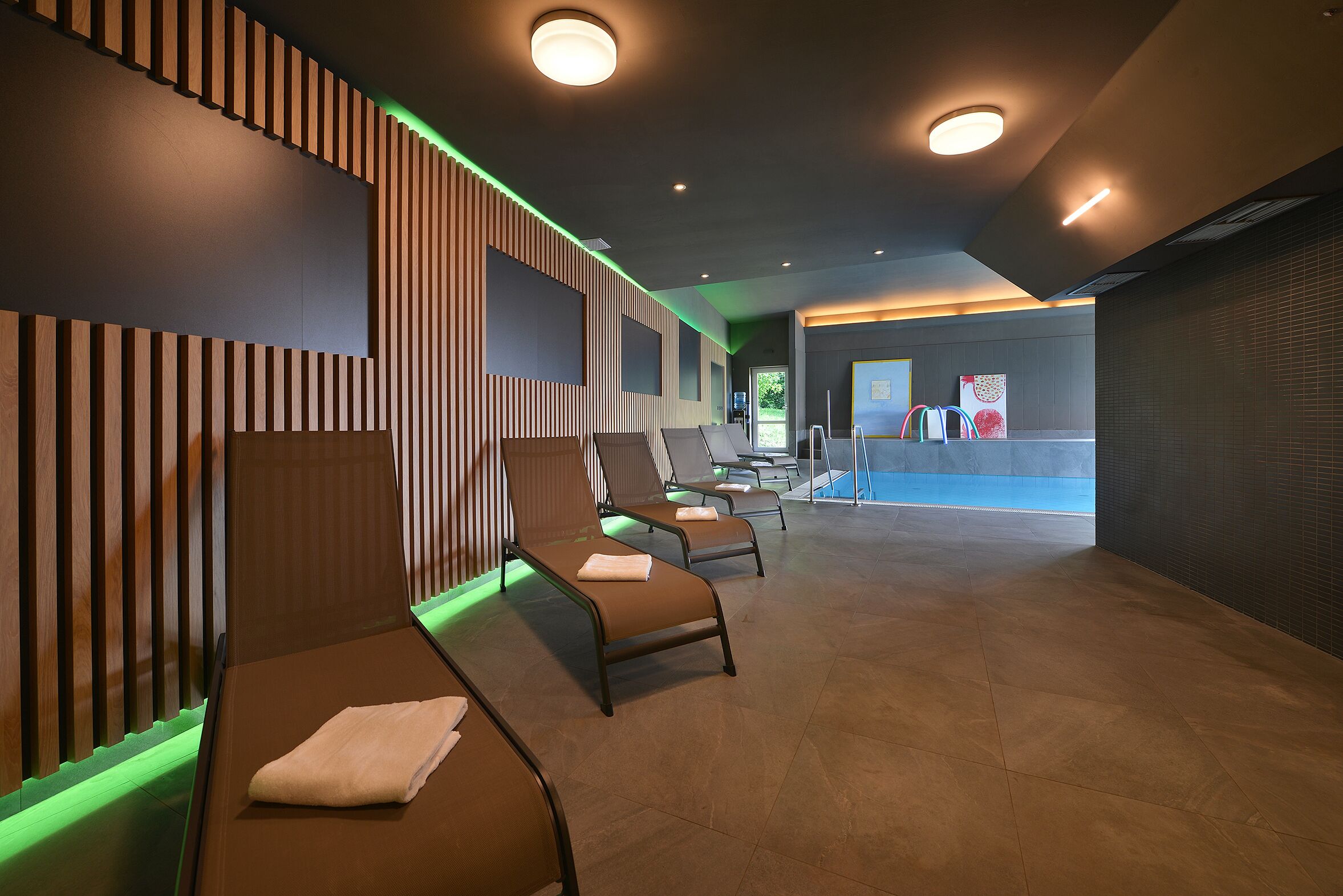 A spa area with reclining chairs, a reception desk, and a view of the outdoors.