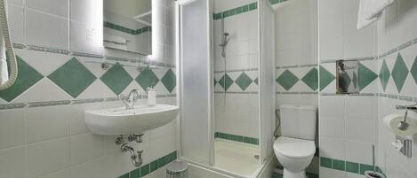 Un baño con lavamanos, inodoro y ducha.