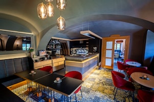 Uma área de bar moderna com balcão, assentos e carpete estampado.