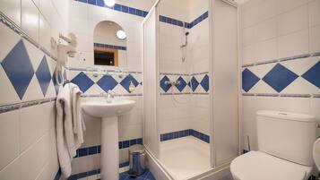 A bathroom with a shower, sink, and toilet.
