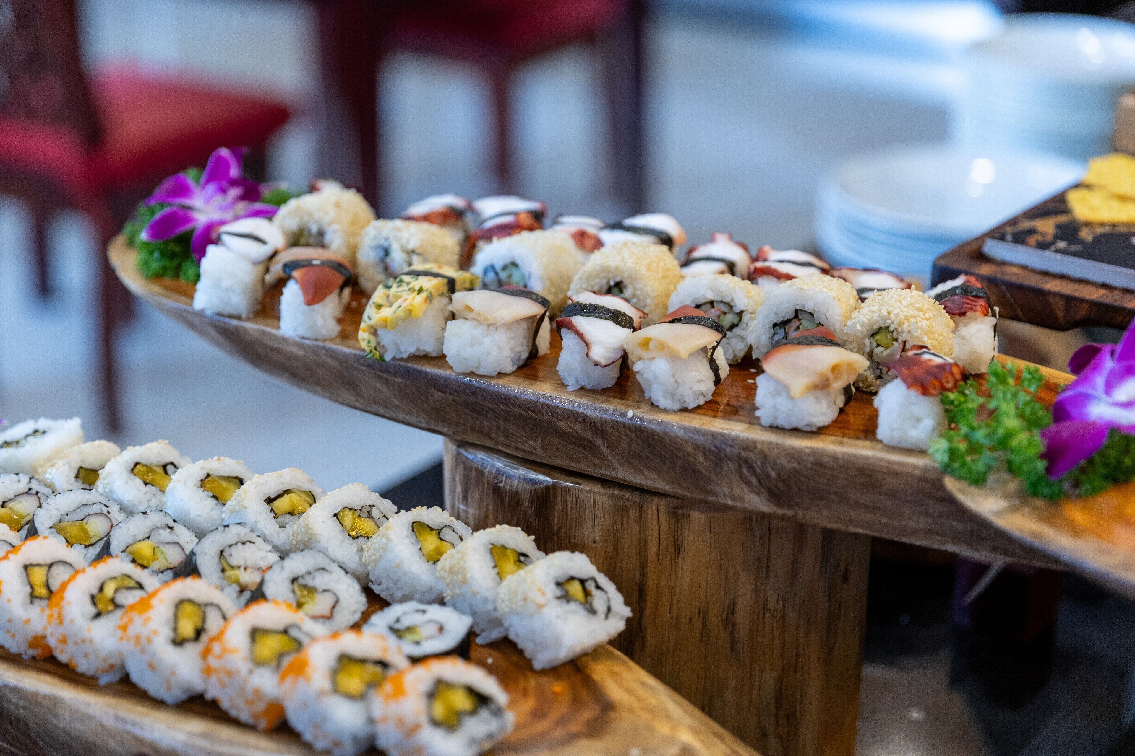 A variety of sushi arranged on wooden serving boards.