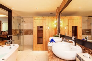 A modern bathroom with a large bathtub, two sinks, a glass shower enclosure, and wooden paneling.
