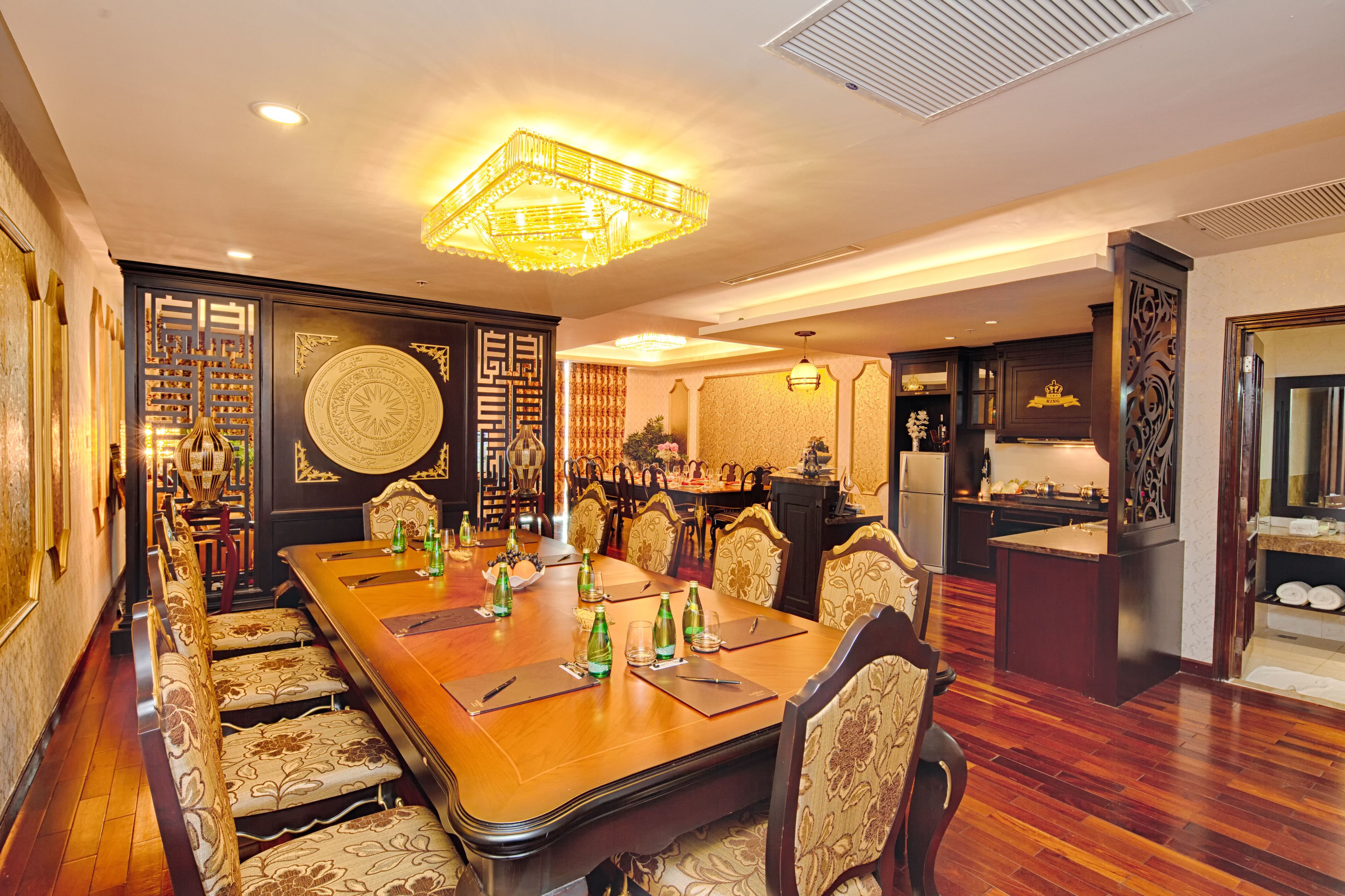 A formal dining room with a long table, chairs, and a chandelier.