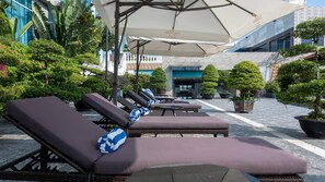Una piscina al aire libre, sombrillas, tumbonas