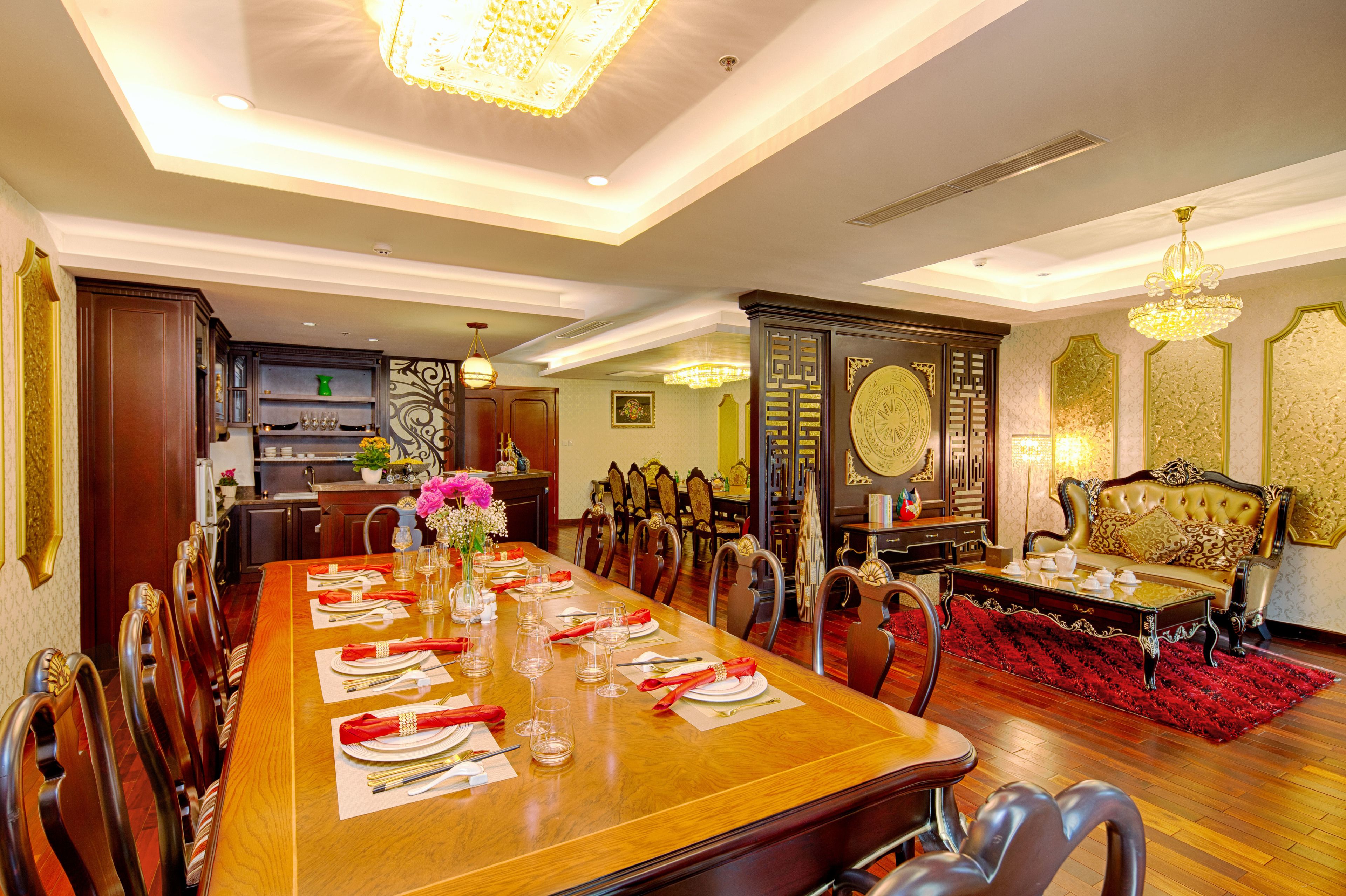 A dining area with a long wooden table set for a meal, surrounded by chairs.