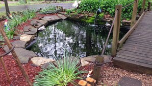 A pond with a wooden deck and stone edging. - Shady Acre Inn and Suites (Branson West)