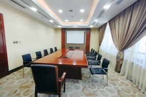 A conference room with a long table, chairs, a projector screen, and curtains. - Mengguzhen Hotel (Fuxin)