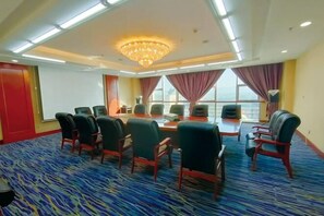 A conference room with a large table, chairs, a projector screen, and a view through large windows. - Mengguzhen Hotel (Fuxin)