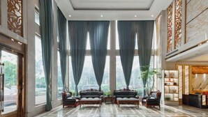 A spacious lobby with large windows, elegant furniture, and a reception area. - Huhua International Hotel (Shanghai Wujing Hua Normal University Branch) (Shanghai)