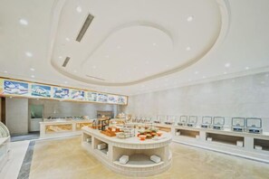 A modern hotel lobby with a central island, a reception desk, and a series of display screens along the wall. - Huhua International Hotel (Shanghai Wujing Hua Normal University Branch) (Shanghai)
