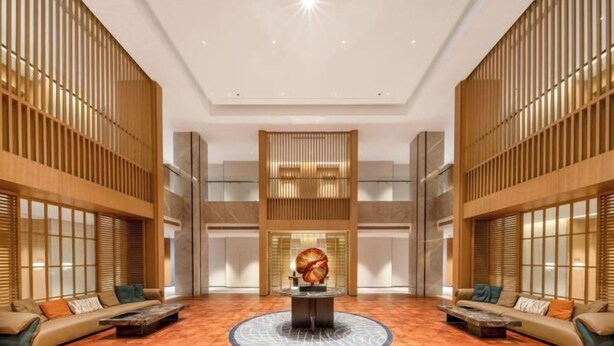 A spacious lobby with a central round table, seating areas, and a decorative wall sculpture. - Huhua International Hotel (Shanghai Wujing Hua Normal University Branch) (Shanghai)