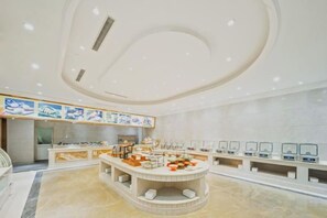 A modern hotel lobby with a central seating area, a reception desk, and a wall-mounted information station. - Huhua International Hotel (Shanghai Wujing Hua Normal University Branch) (Shanghai)