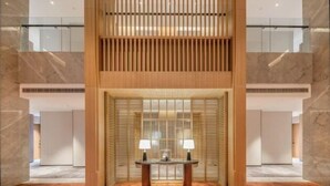 A lobby with a wooden reception desk, marble flooring, and a glass railing. - Huhua International Hotel (Shanghai Wujing Hua Normal University Branch) (Shanghai)