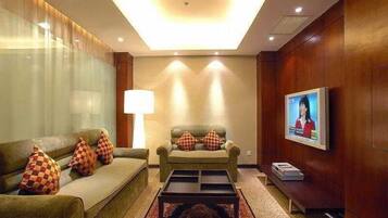 A modern living room with a sofa, a coffee table, and a TV on the wall.