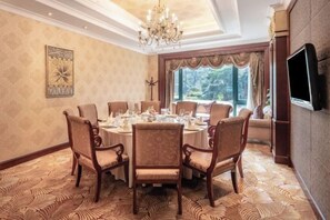 A dining room with a round table, chairs, and a chandelier. - Evergrande World MICE Center (Jintang)