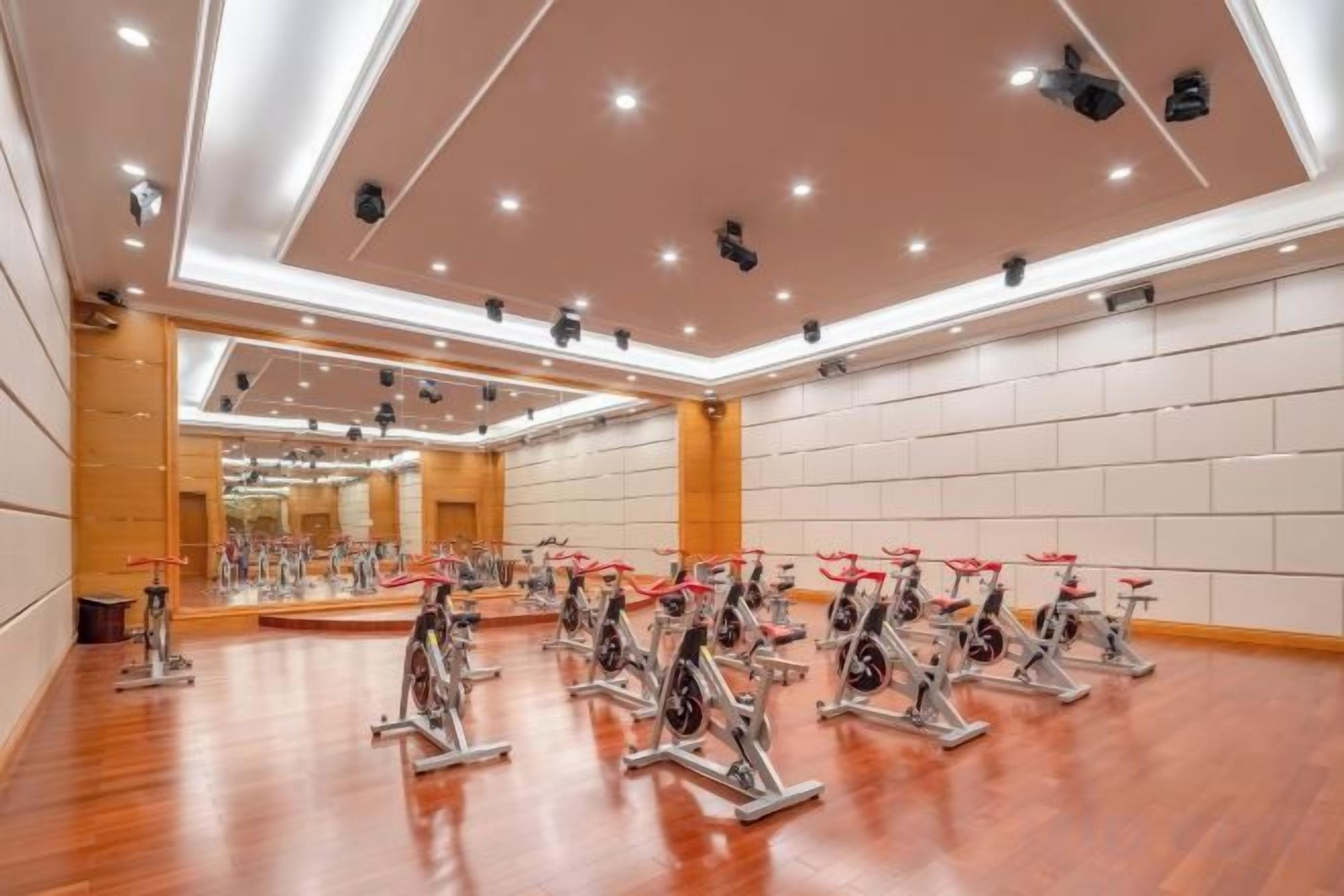 Una habitación amplia con varias bicicletas estáticas dispuestas en filas.