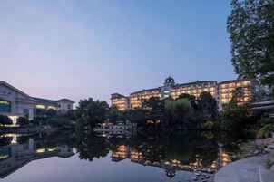Un hotel con varias edificaciones, una masa de agua reflectante y un cielo despejado.