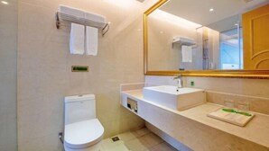 A modern bathroom with a white toilet, a sink with a mirror above it, and a towel rack. - Vienna International Hotel (Shenzhen Xiashuijing Metro Station) (Shenzhen)