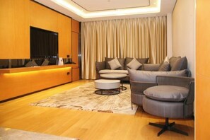 Una sala moderna con un sofá, sillones y una mesa de centro.