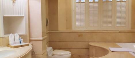 A bathroom with a bathtub, toilet, and vanity.