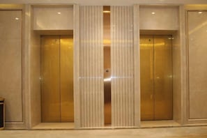 A set of double doors with a vertical panel in the center, likely an elevator or service entrance. - Agile Hotel (Zhongshan)
