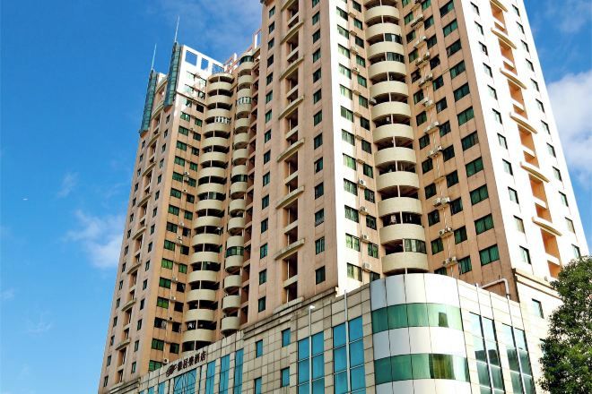 Un immeuble de grande hauteur doté de nombreux balcons et d’une façade moderne en verre.