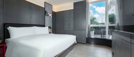 A modern hotel room with a large bed, a TV, and a view of the outdoors.