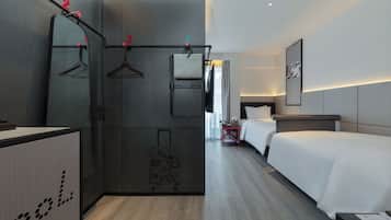 Una habitación de hotel con armario, cama, mesita de noche y espejo.