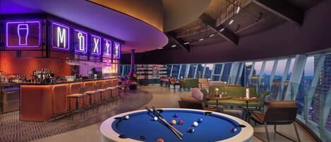 A modern bar area with neon signage, a pool table, and a city view.