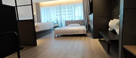 Een moderne hotelkamer met een groot bed, een bank en een bureau.