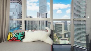 Un apartamento alto con un amplio ventanal que ofrece vistas de la ciudad.