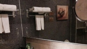A bathroom with a large mirror, a sink, and a towel rack. - Zhuhai Harmony Resort Hotel (Zhuhai)