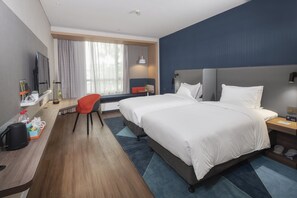 A hotel room with a large bed, a desk with a computer, a chair, a TV, and a window with curtains. - Holiday Inn Express Shanghai Chongming by IHG (Shanghai)