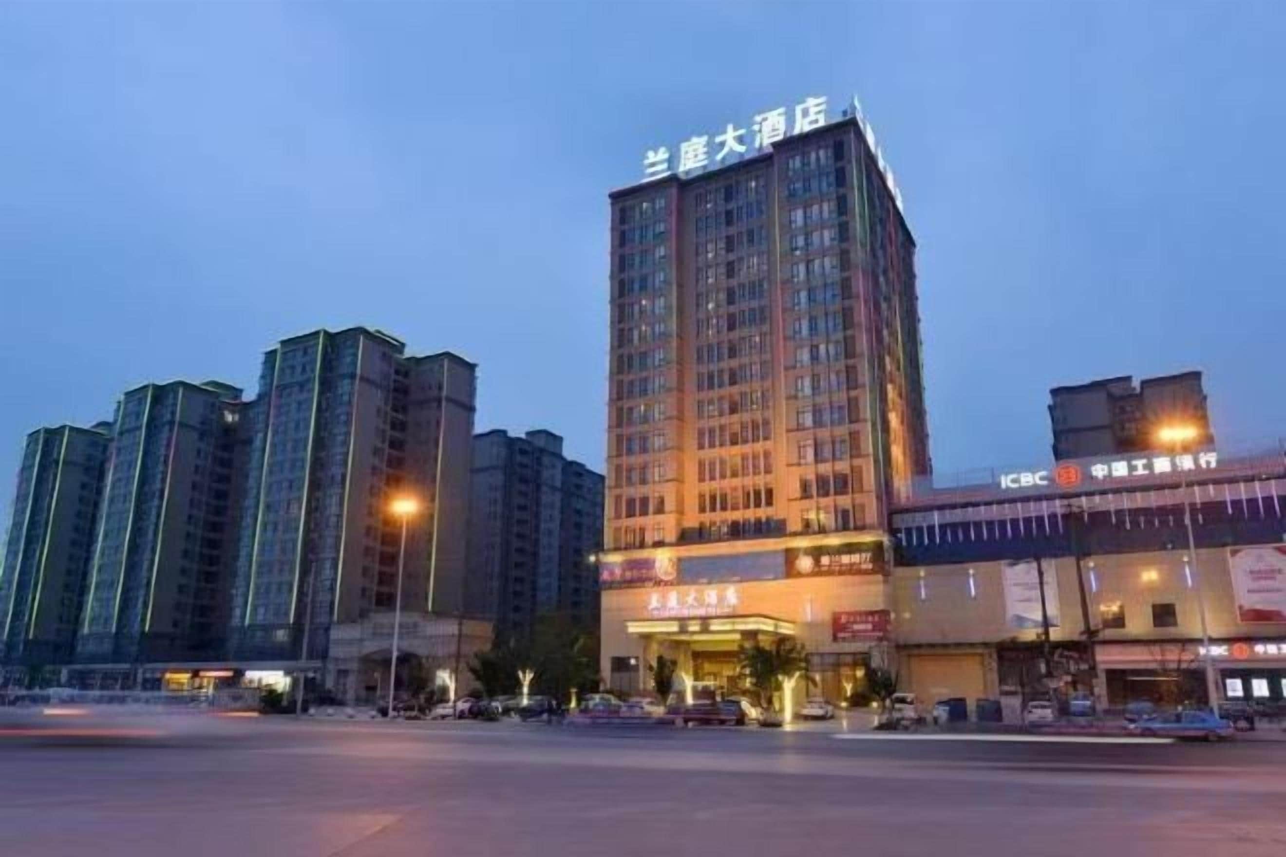 Un edificio de hotel moderno con múltiples pisos, una entrada amplia y un letrero que indica que es un hotel.