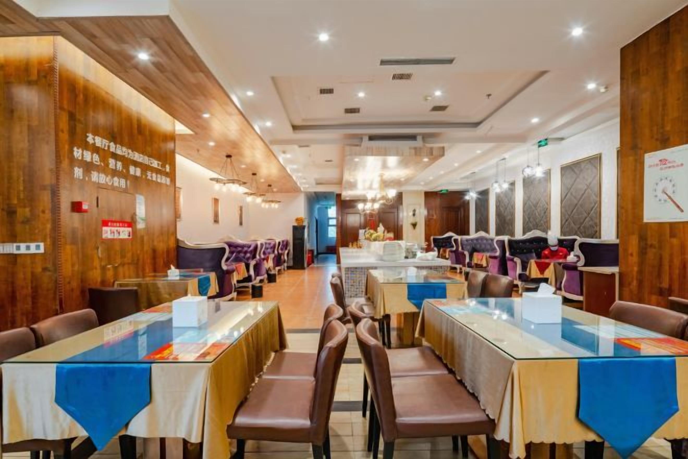 A restaurant with multiple tables and chairs, wooden paneling on the walls, and a counter area in the background.