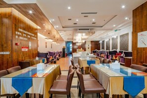A restaurant with multiple tables and chairs, wooden paneling on the walls, and a counter area in the background. - Lanting Hotel(Qionglai High-speed Railway Station, chengdu) (Chengdu)