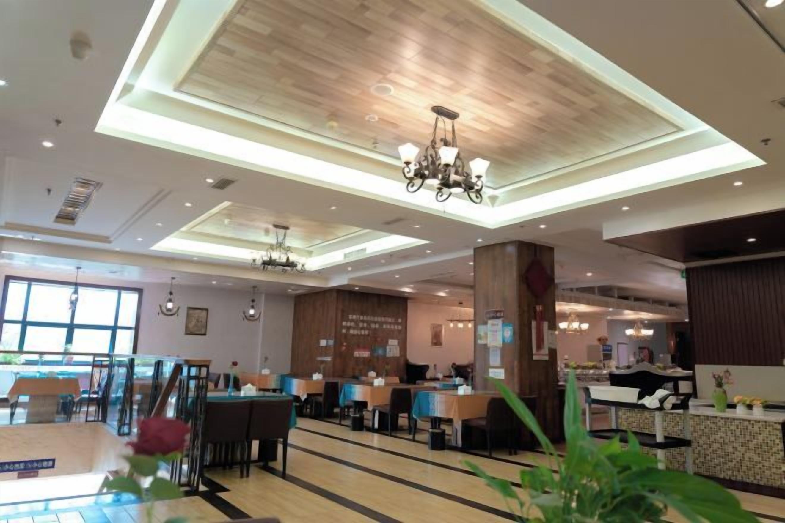 A spacious hotel lobby with high ceilings, chandeliers, and a variety of seating arrangements.