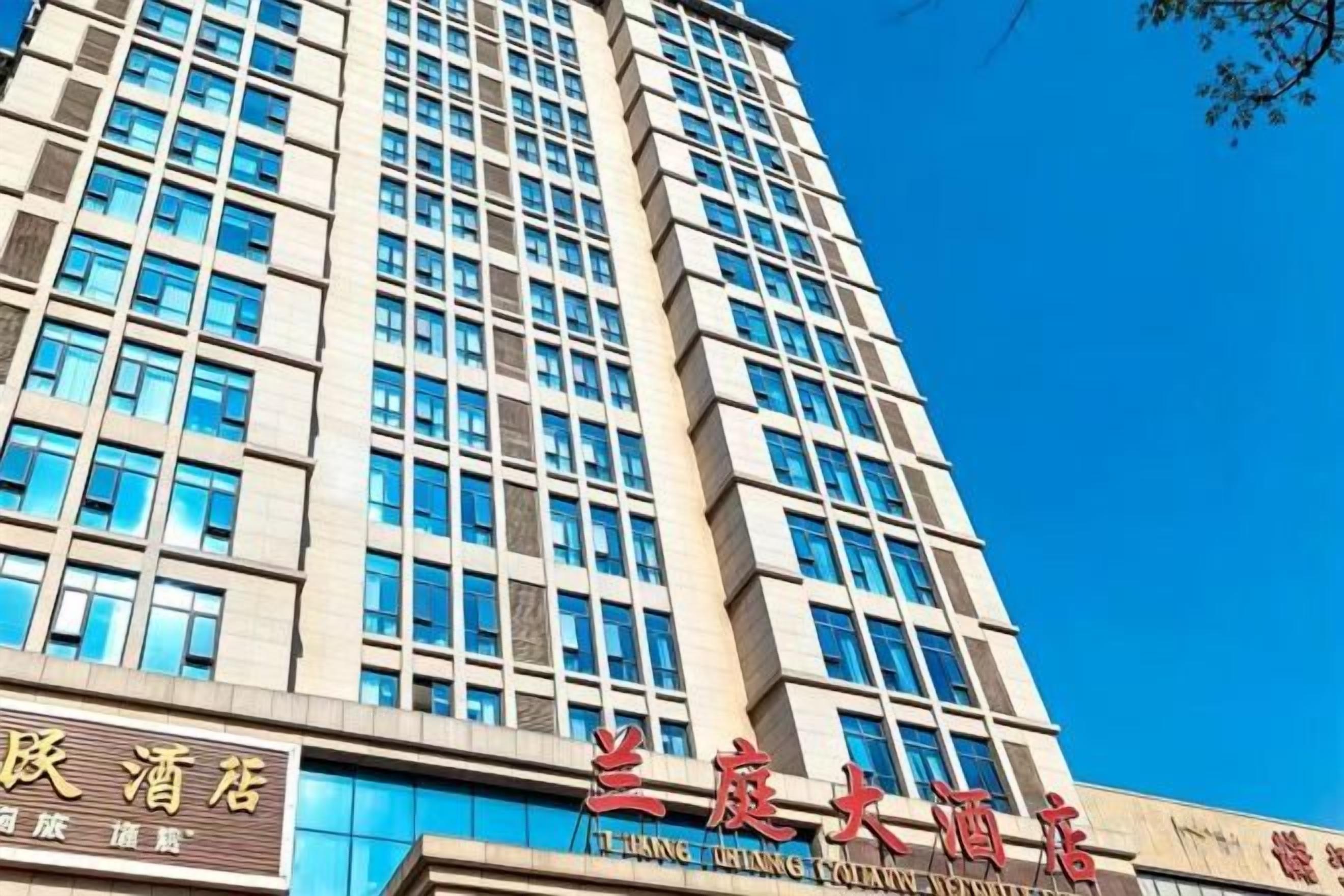 Un edificio de hotel moderno con varios pisos y un cielo azul despejado.