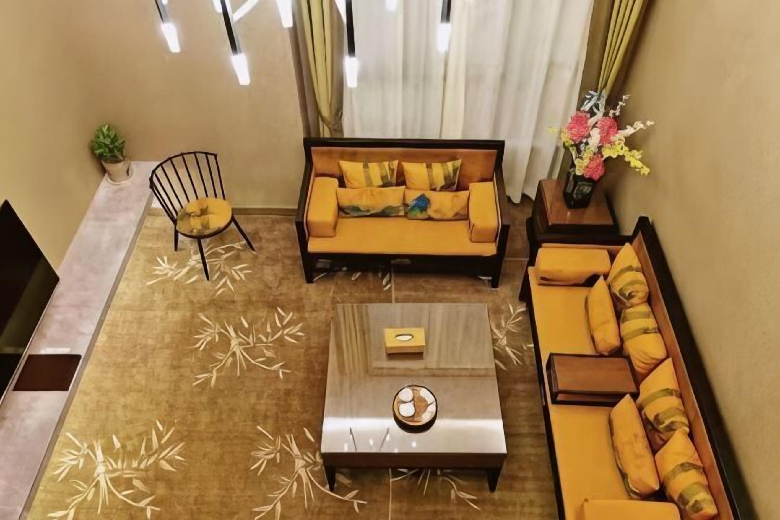 A living room with a sofa, armchairs, a coffee table, and a TV.
