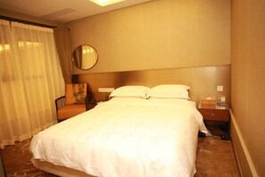 A hotel room with a bed, a chair, a bedside table, a mirror, and a window with curtains. - Cuizhu Hotel (Shenzhen)