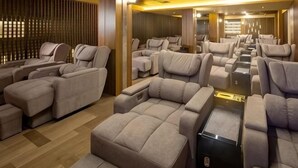 Une pièce dotée de plusieurs canapés inclinables et d’un fauteuil de massage intégré.