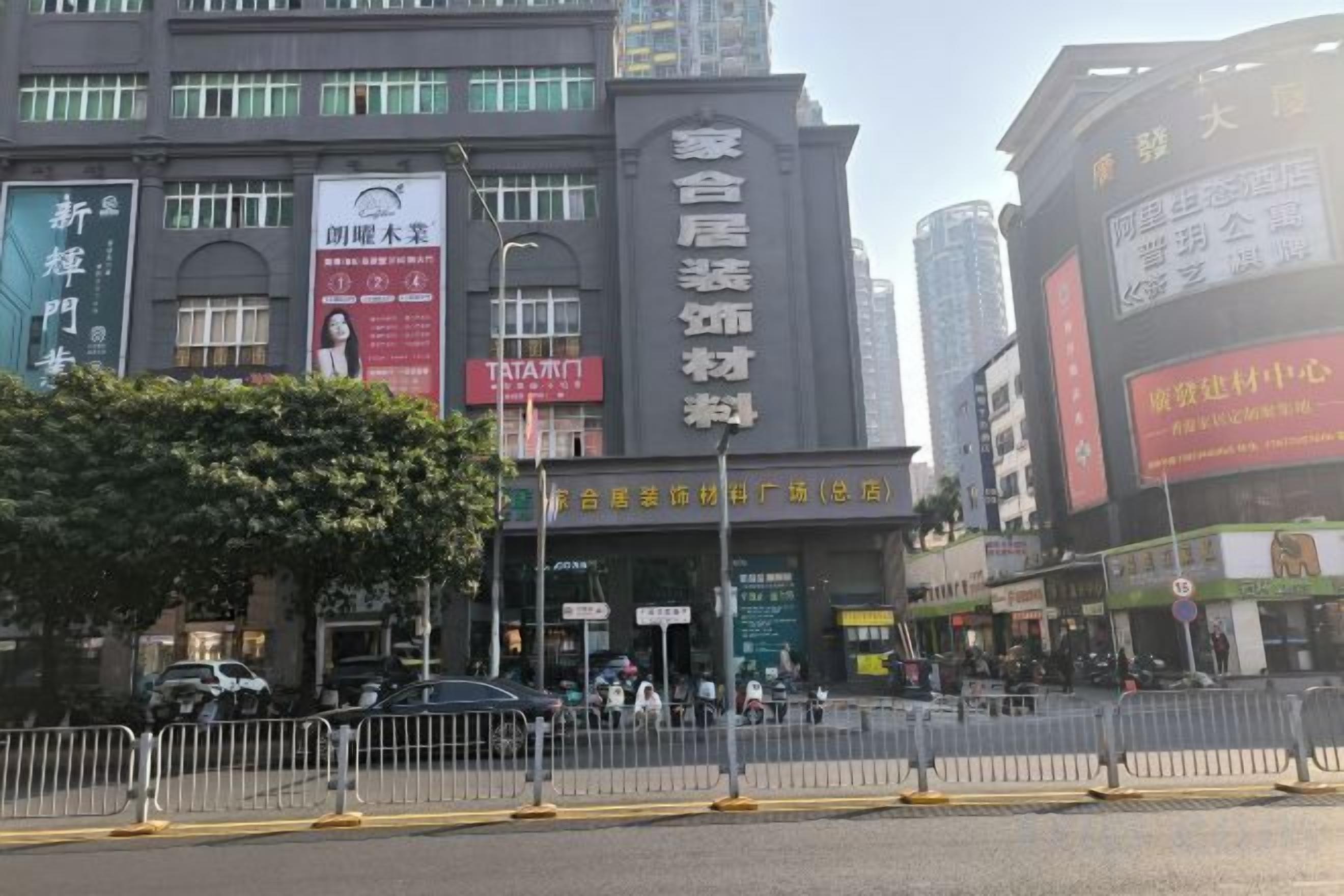 A commercial building with multiple storefronts, including a visible sign for a restaurant and a large advertisement banner.