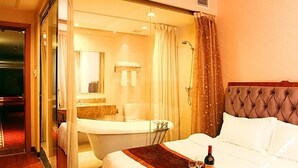 A hotel room with a bed, a bathroom with a bathtub, and a shower. - Hot Spring Hotel (Beijing)
