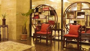 A traditional interior with a sofa, chairs, and a decorative shelf. - Hot Spring Hotel (Beijing)