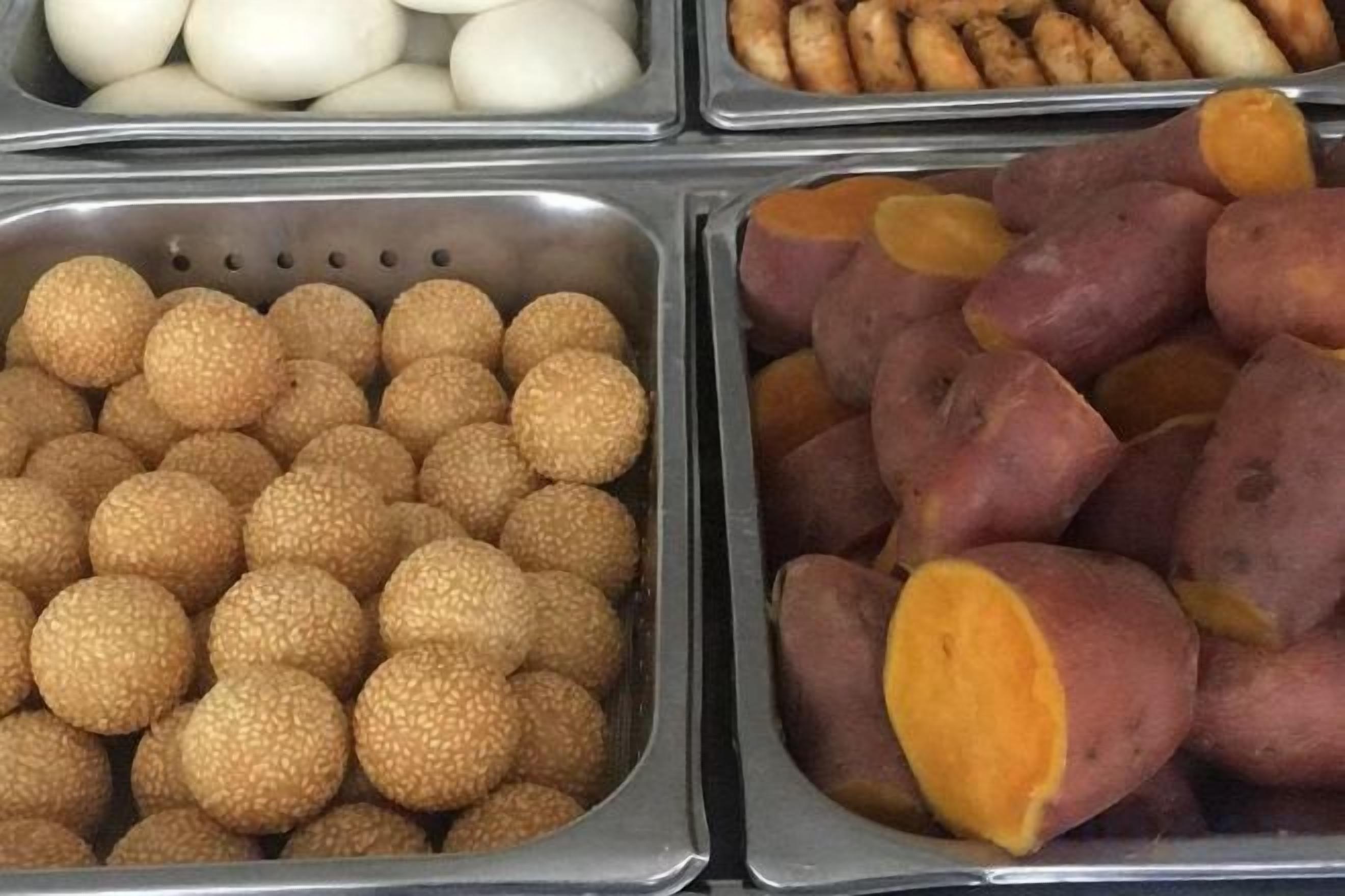 Variedad de alimentos en recipientes metálicos.