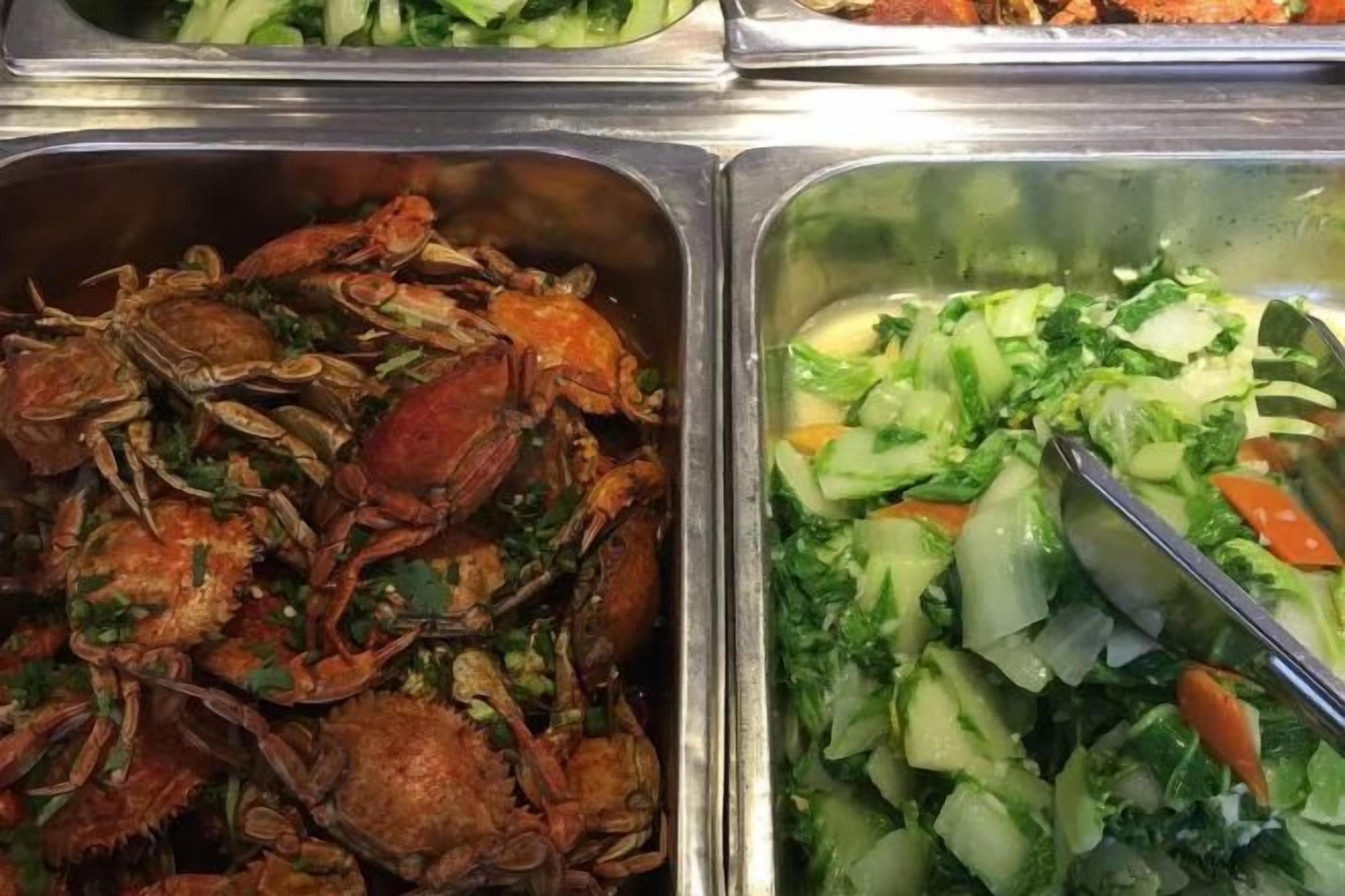 A buffet with seafood and a vegetable salad.