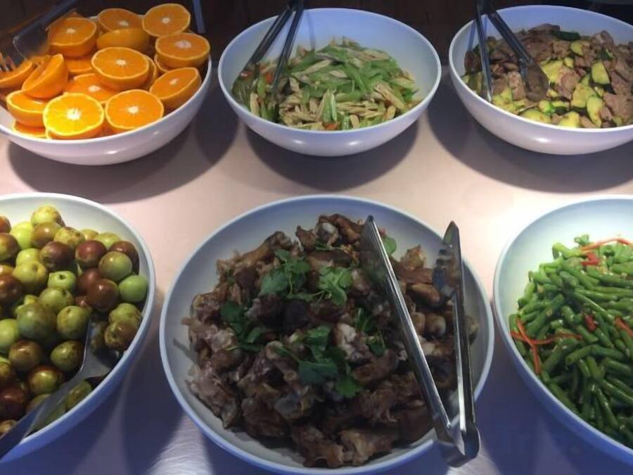 A table with various dishes including fruits, vegetables, and meat.