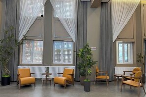 A hotel lobby with large windows, curtains, and seating arrangements. - Hejia Inn (Beijing Tsinghua) (Beijing)